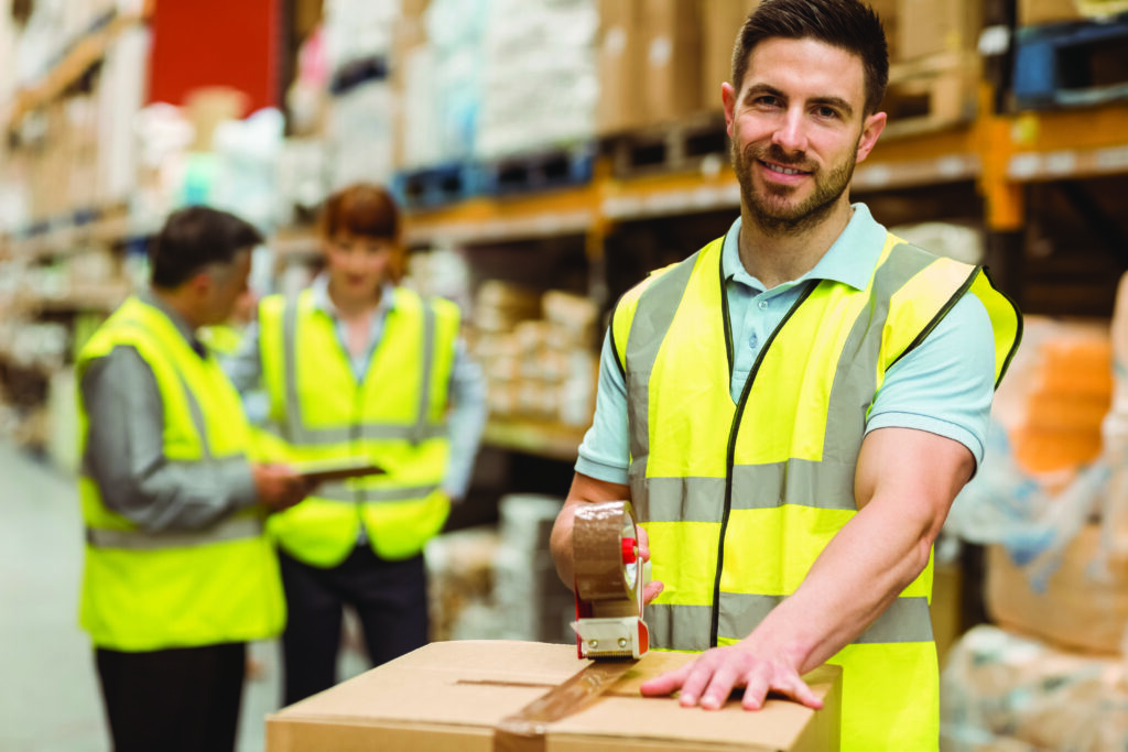 a warehouse picker packer taping up a box 